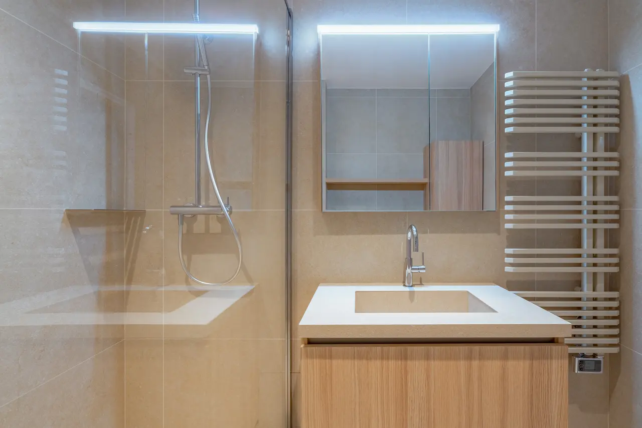 Douche de plain-pied, miroir et sèche-serviettes.